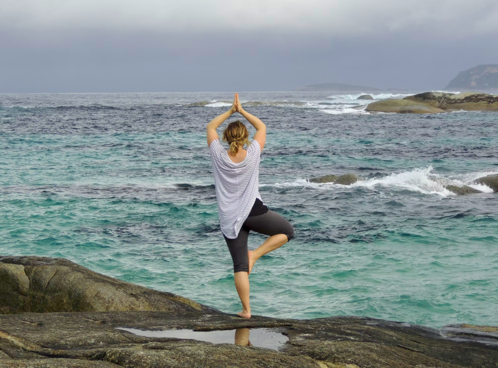 balancing woman by the ocean