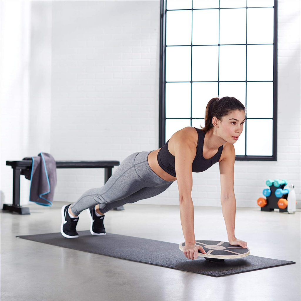 Woman in a raised plank on a balance board.